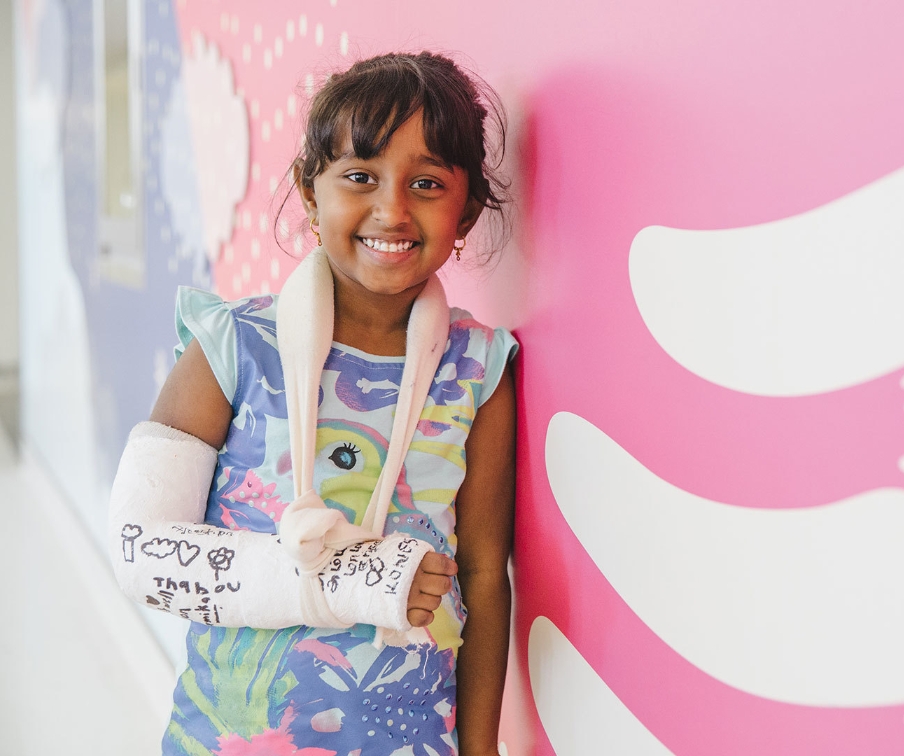 Girl smiling with a cast on her right arm