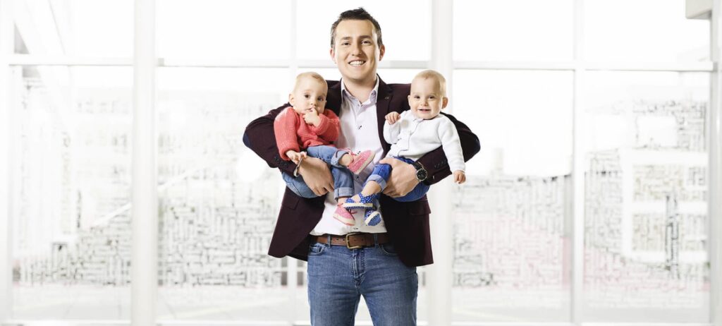 Man holding twins in his arms