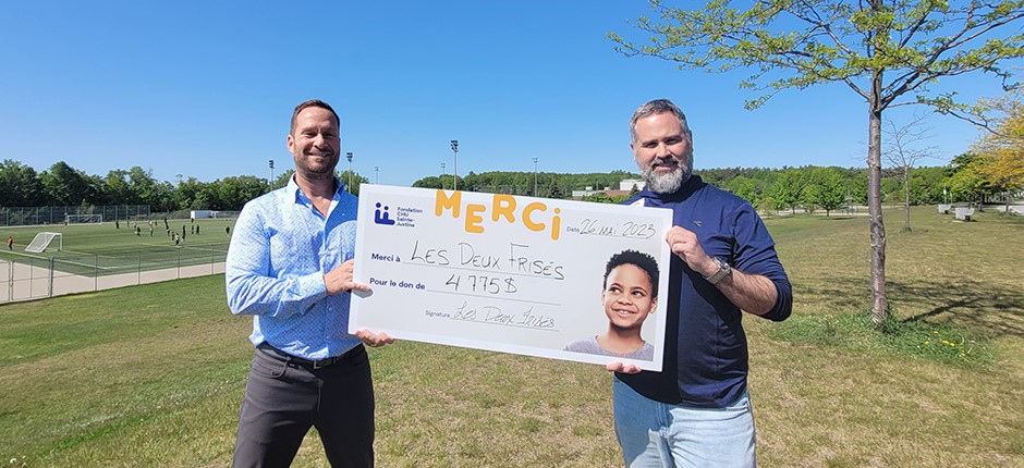 Donation from Les Deux Frisés presented by two men