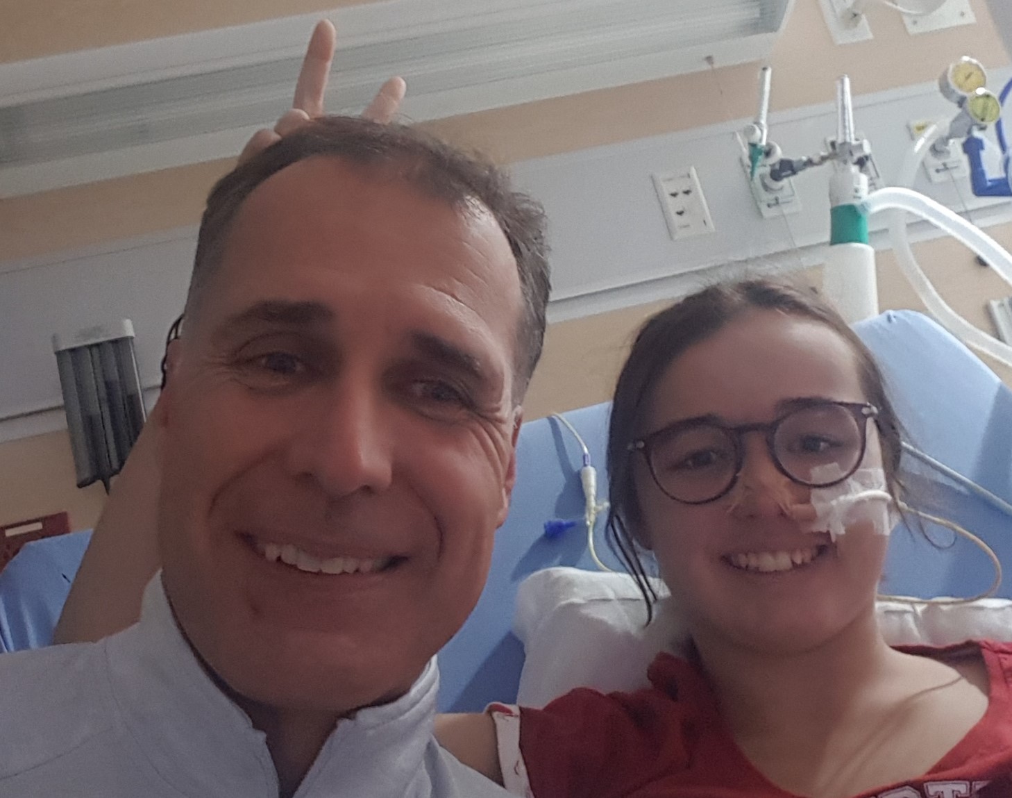 Anne-Marie et son papa en auto-portrait, souriants, dans sa chambre d'hôpital. 