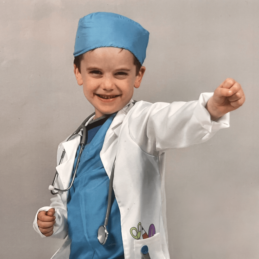 un enfant déguisé en médecin léve le poing en l'air