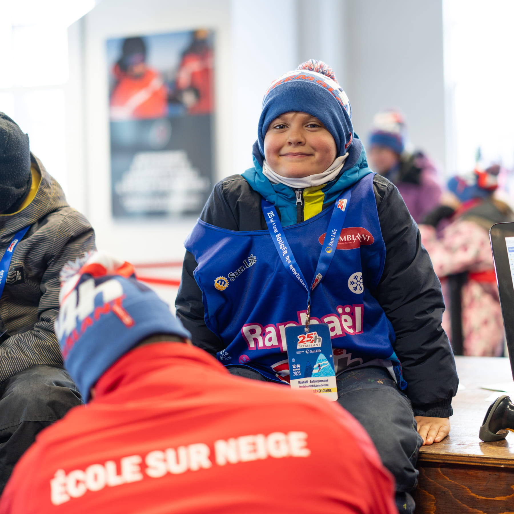 Une personne aide un enfant à enfiler ses skis.  