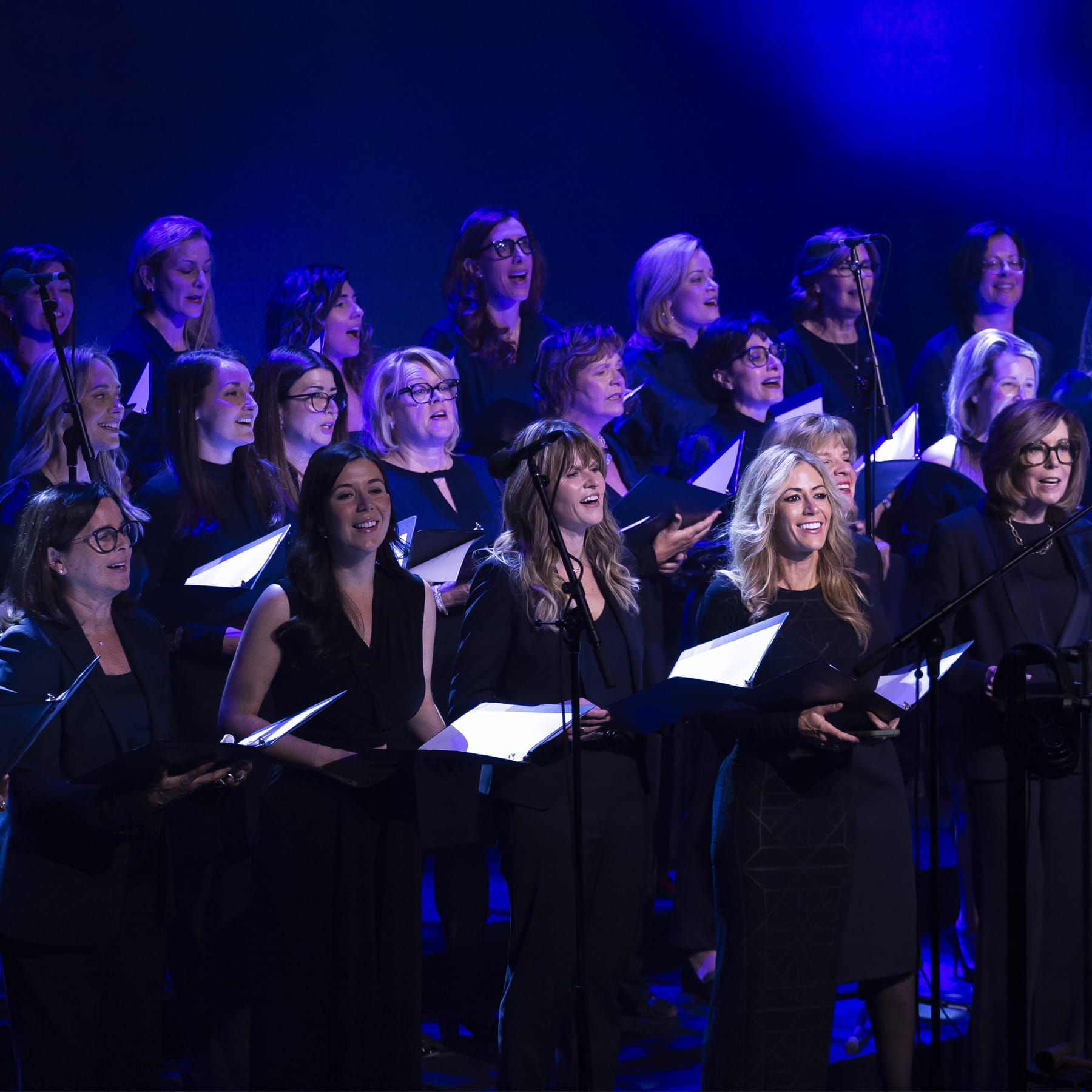 Groupe de femmes en concert sur une estrade.