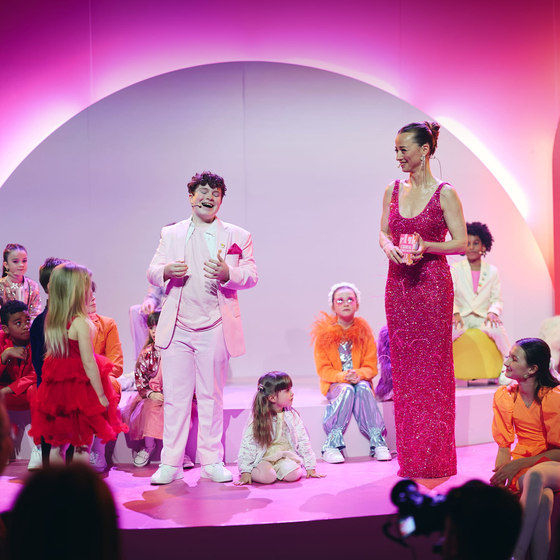 Un enfant et une femme en habits de soirée animent un évènement.