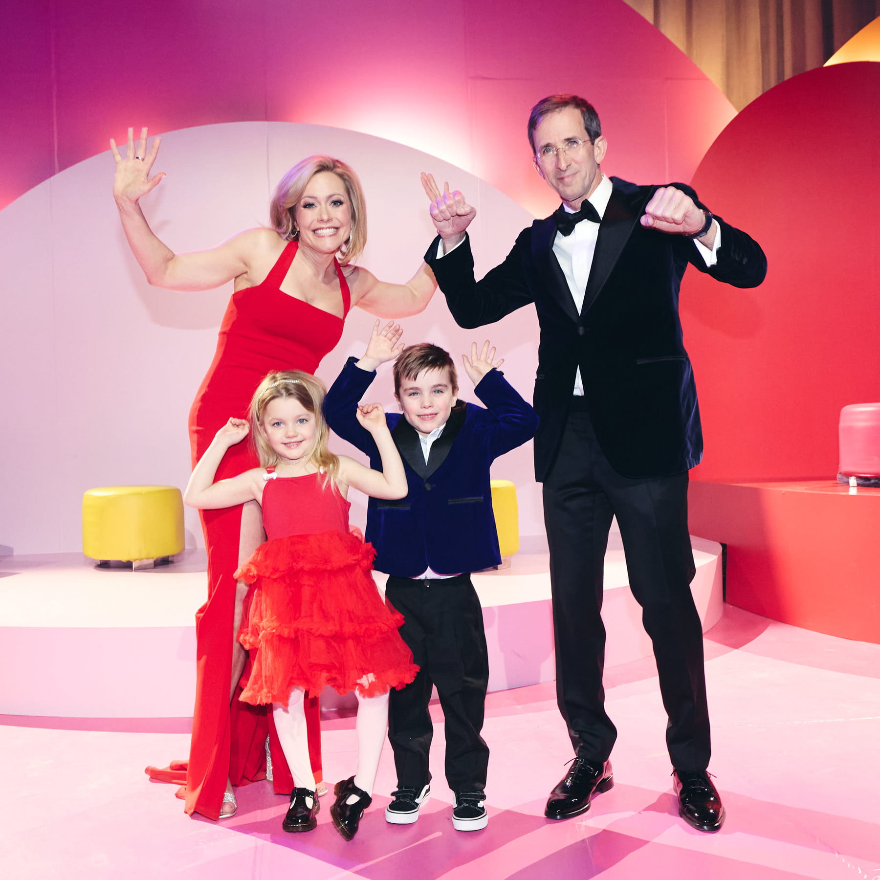 Une femme et un homme en habits de soirée, accompagnés de deux enfants.