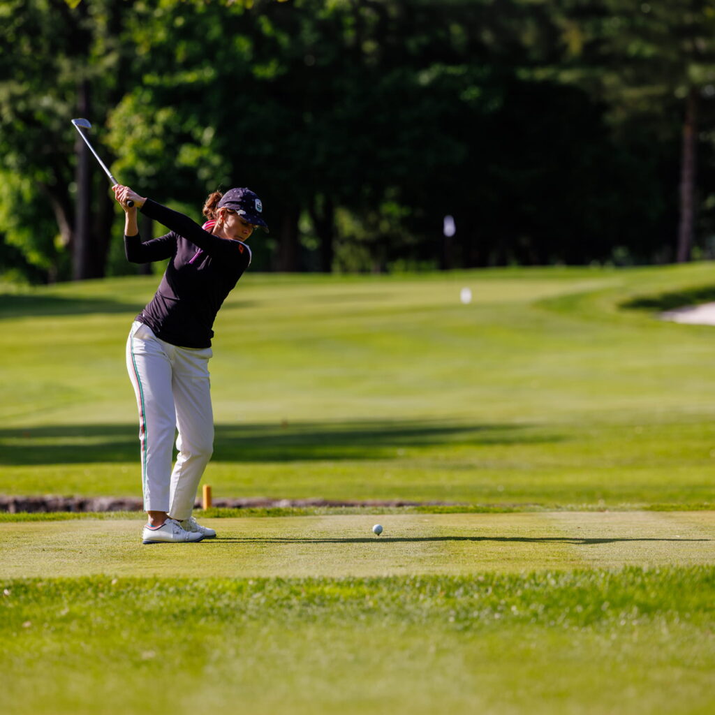Une femme joue au golf. 