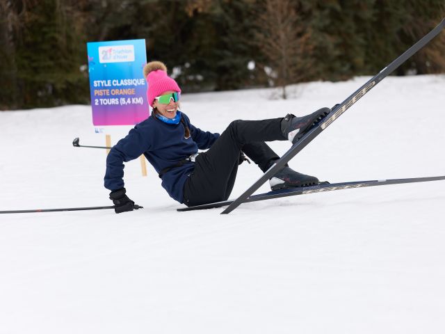 A woman falls while cross-country skiing.