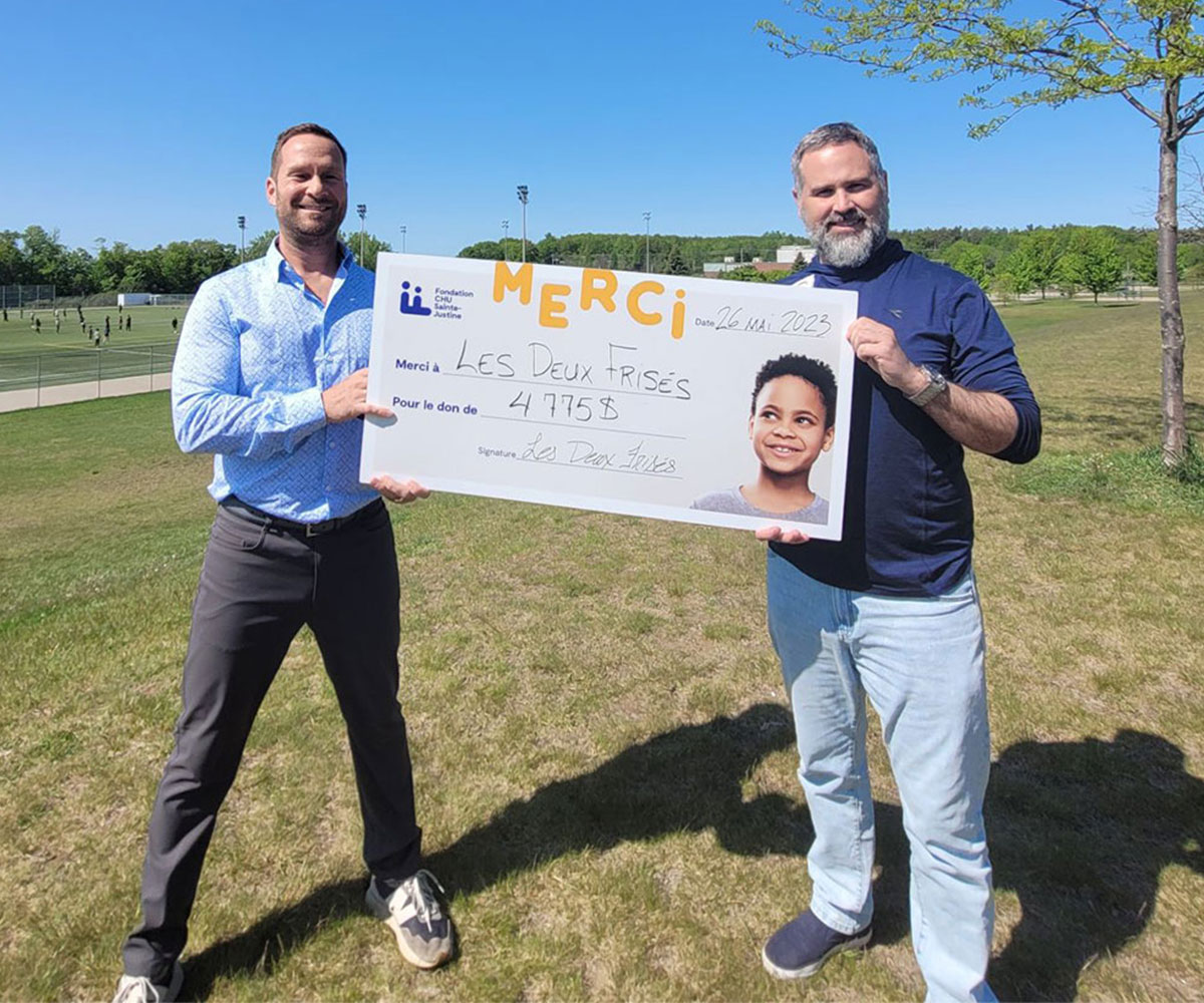 Deux personnes tenant un ch&egrave;que remis &agrave; la Fondation CHU Sainte-Justine.